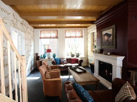 Wohnzimmer mit Treppe, Ledersofa und Kamin
