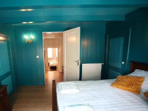 Schlafzimmer mit Doppelbett und Fernseher
