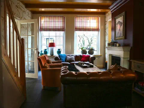 Wohnzimmer mit Ledersofa, Kamin und Fernseher