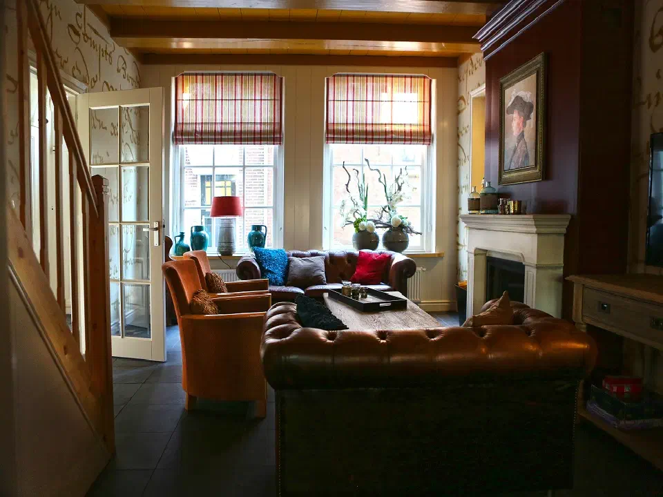 Woonkamer met chesterfieldbank, schouw en tv