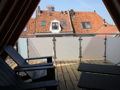 Loggia mit Liegestühlen und Blick über die Dächer